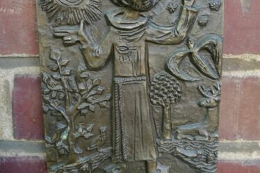 Die Bronzetafel des Franziskuspreis hängt an der Backsteinwand